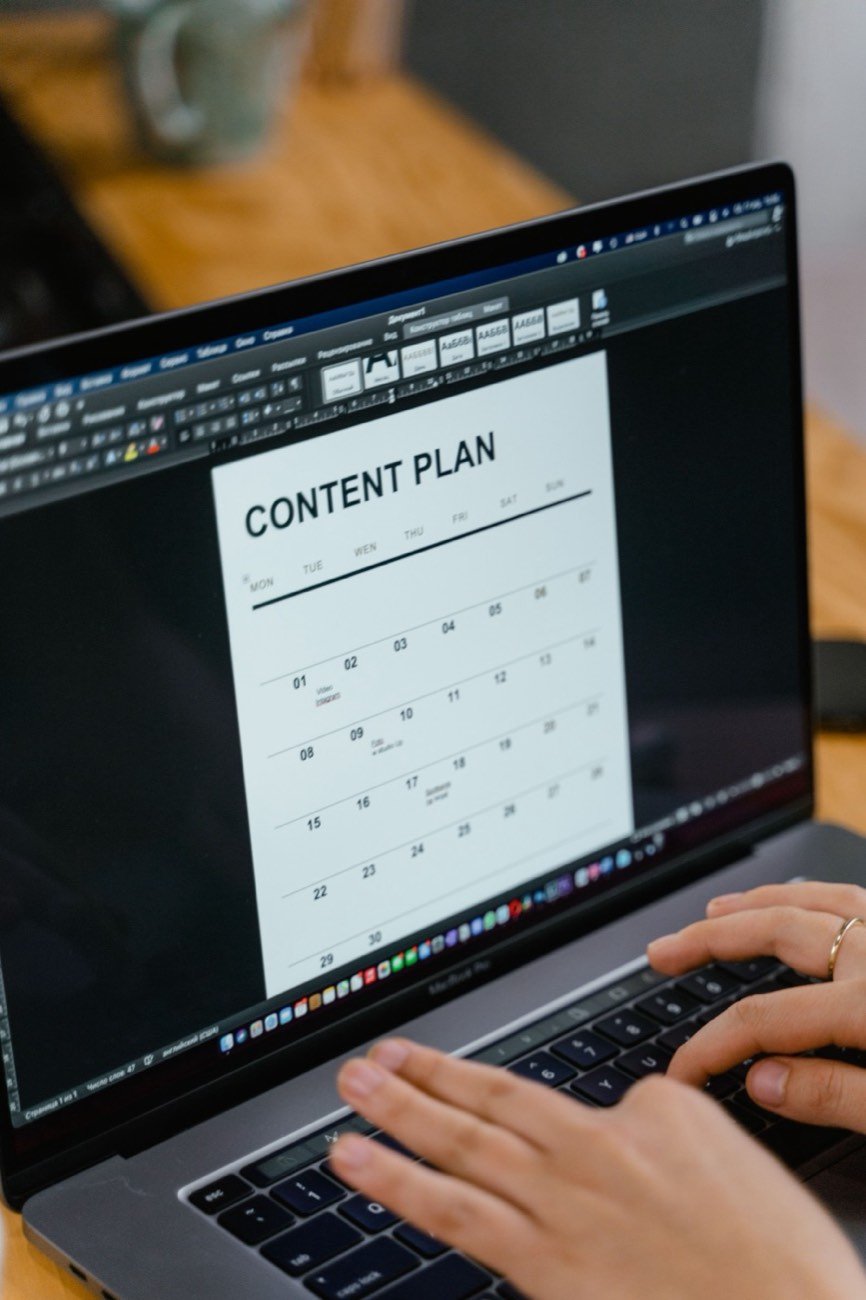 A writer working through a monthly content plan on a laptop